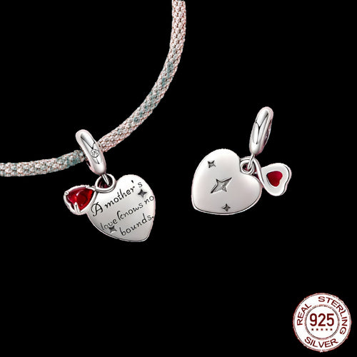 Silver heart-shaped pendant with red gemstone and engraved text on a green background, featuring a 'Real Sterling Silver 925' stamp.