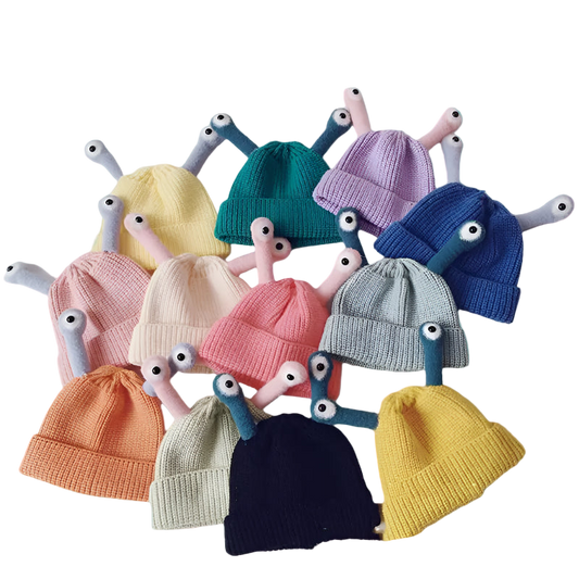 Colorful knit baby hats with toy arms and heads on a white background