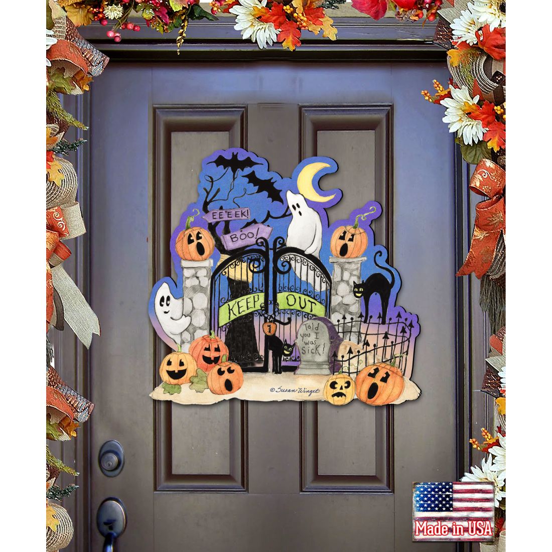 Halloween door decoration with pumpkins, ghosts, and a gate on a door.