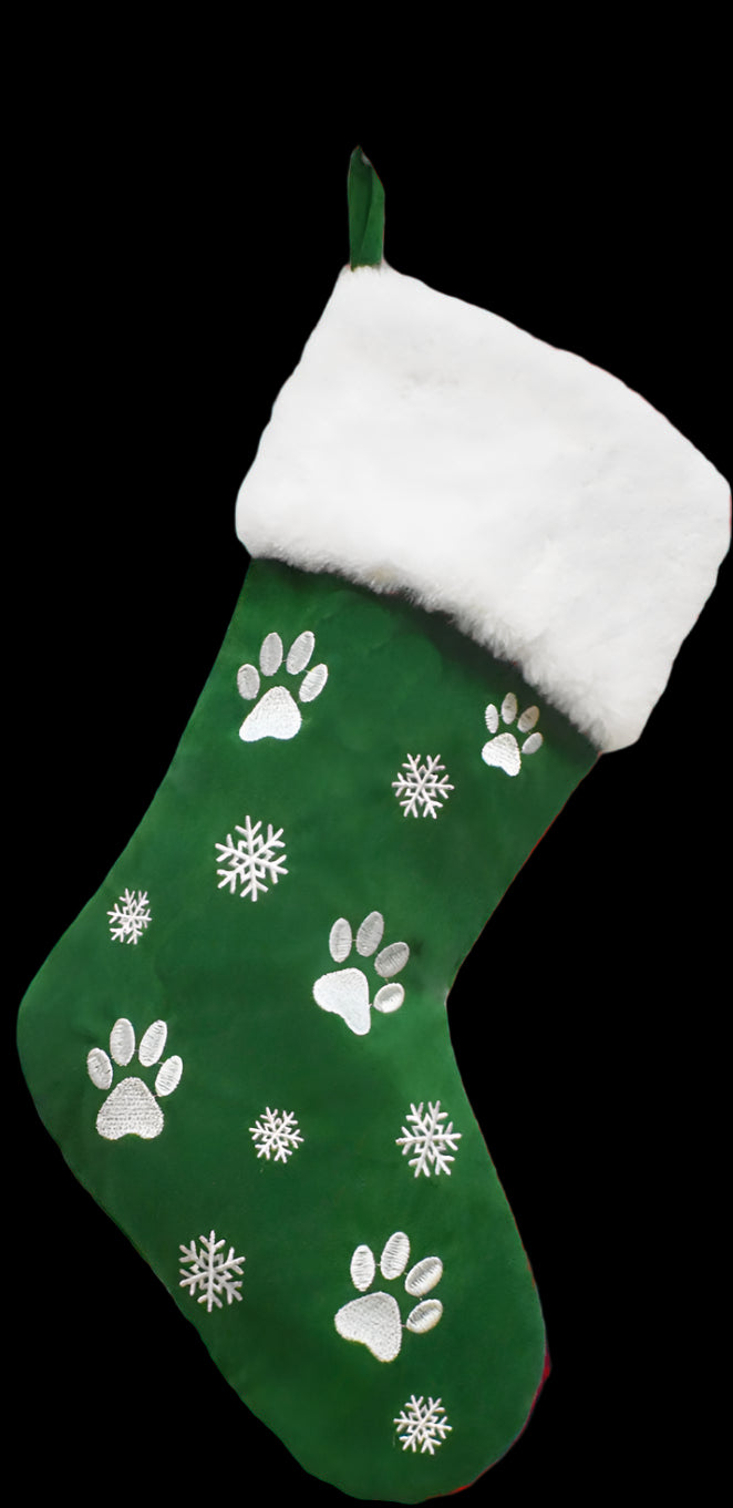 Green Christmas stocking with paw prints and snowflakes, hanging on a white wall.