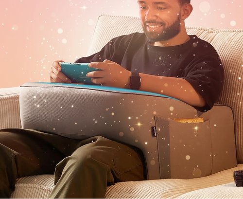 Man sitting on a couch using a tablet with a colorful background