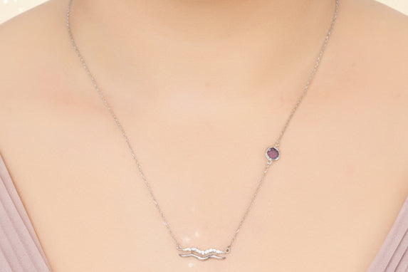 Necklace with a pendant worn by a person on a plain background