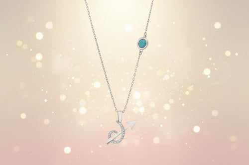 Silver necklace with a turquoise pendant and arrow design on a white background