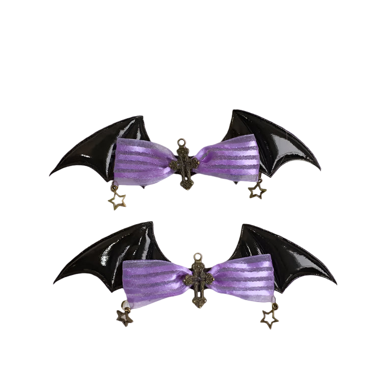 Two black bat-shaped hair clips with purple ribbons on a white background