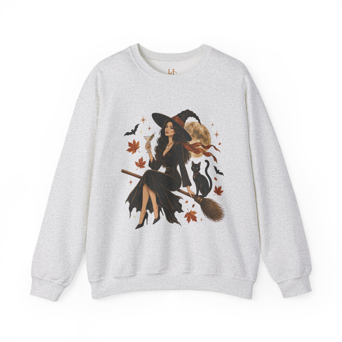 A light heather gray crewneck sweatshirt featuring a large graphic print of a witch riding a broomstick, surrounded by black cats, bats, autumn leaves, and a cat hat.