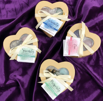 Heart-shaped boxes with stones and ribbons on a white surface with crystals in the background