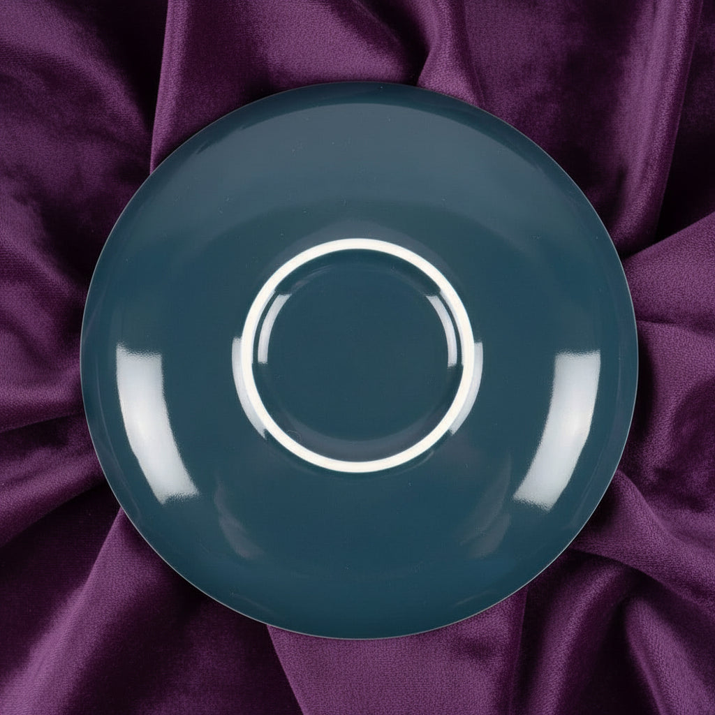 Teal ceramic saucer on a white background