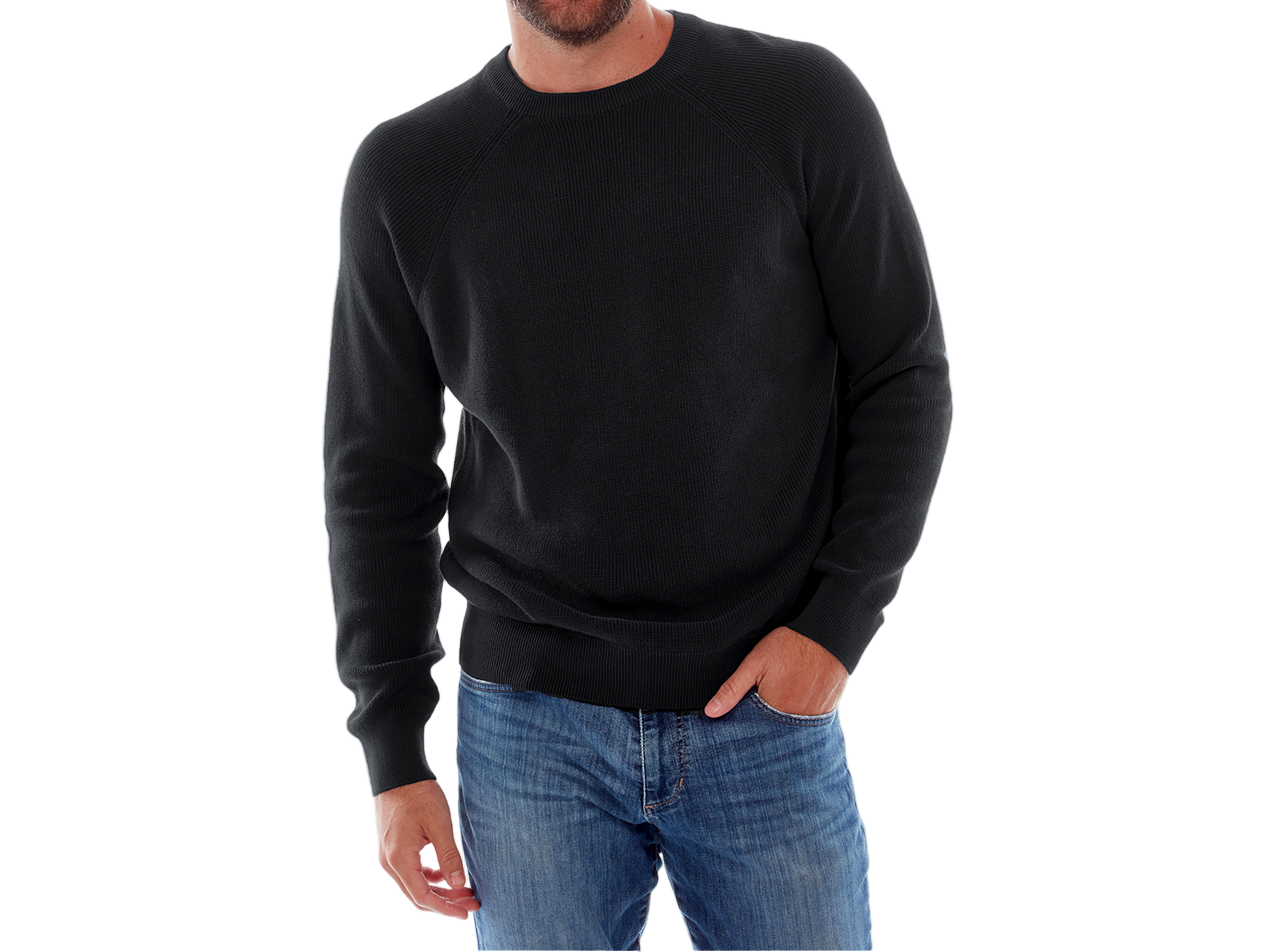 Man wearing a black sweater and blue jeans on a white background