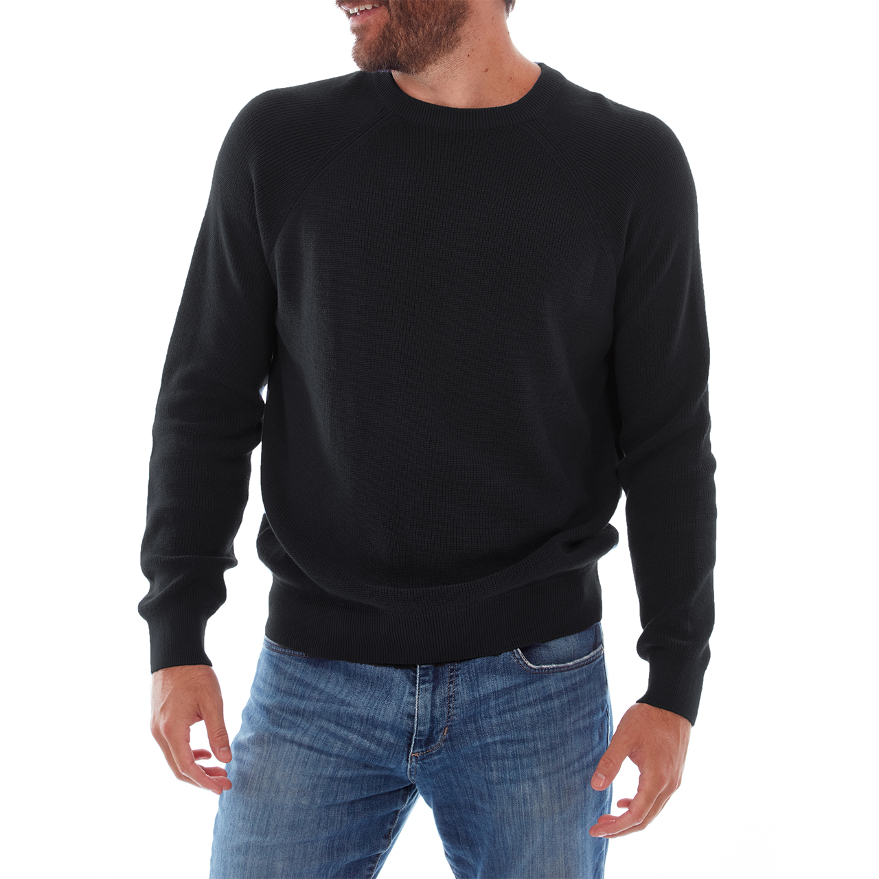 Man wearing a black sweater and blue jeans on a white background