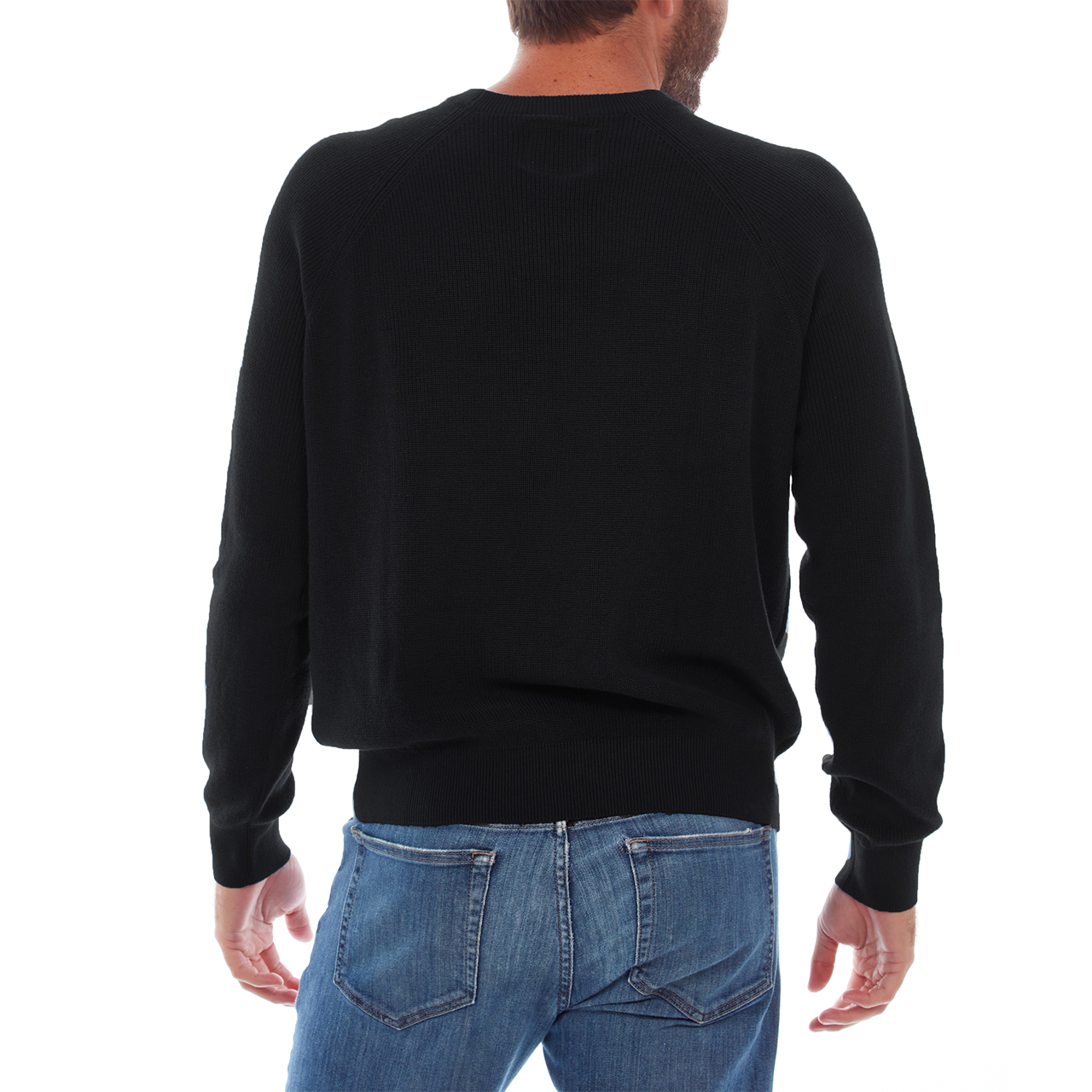 Person wearing a black sweater and blue jeans on a white background
