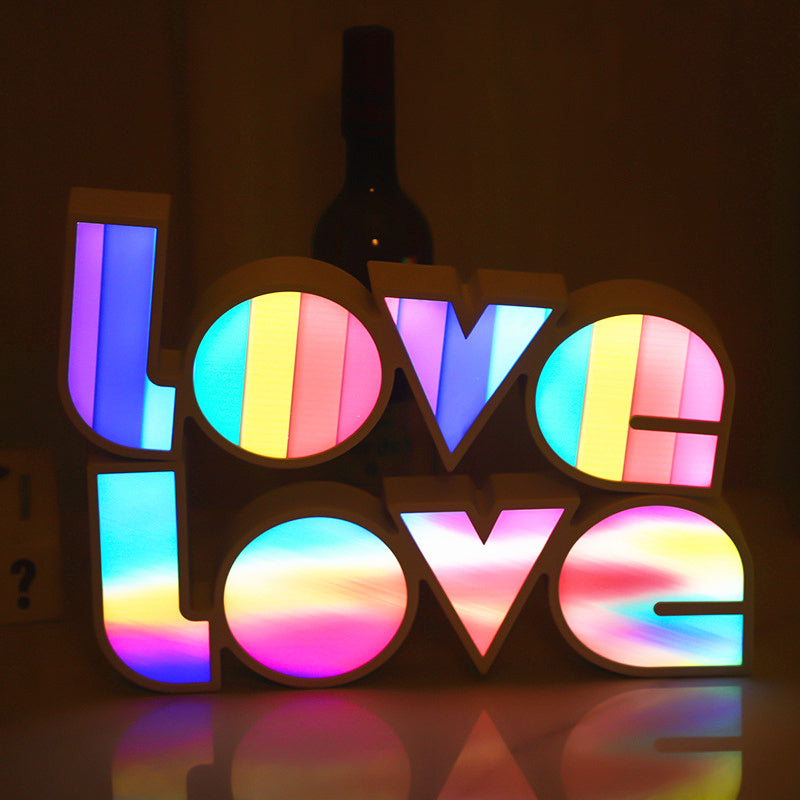 Colorful 'LOVE' sign with rainbow lights on a dark background