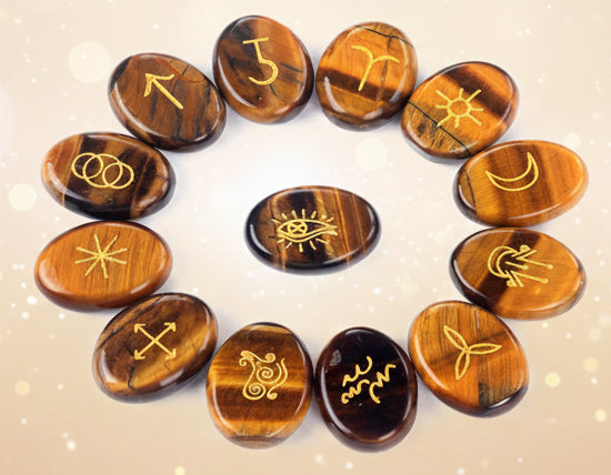 Set of tumbled stones with engraved symbols on a white background