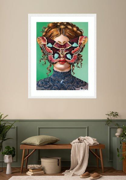 Framed artwork of a woman with a colorful mask in a room with a bench and plants.