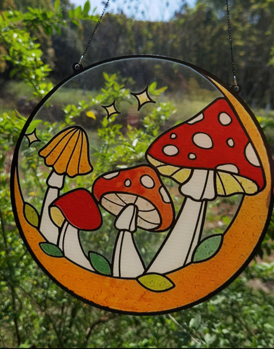 Decorative circular panel with mushroom design held in front of a natural background