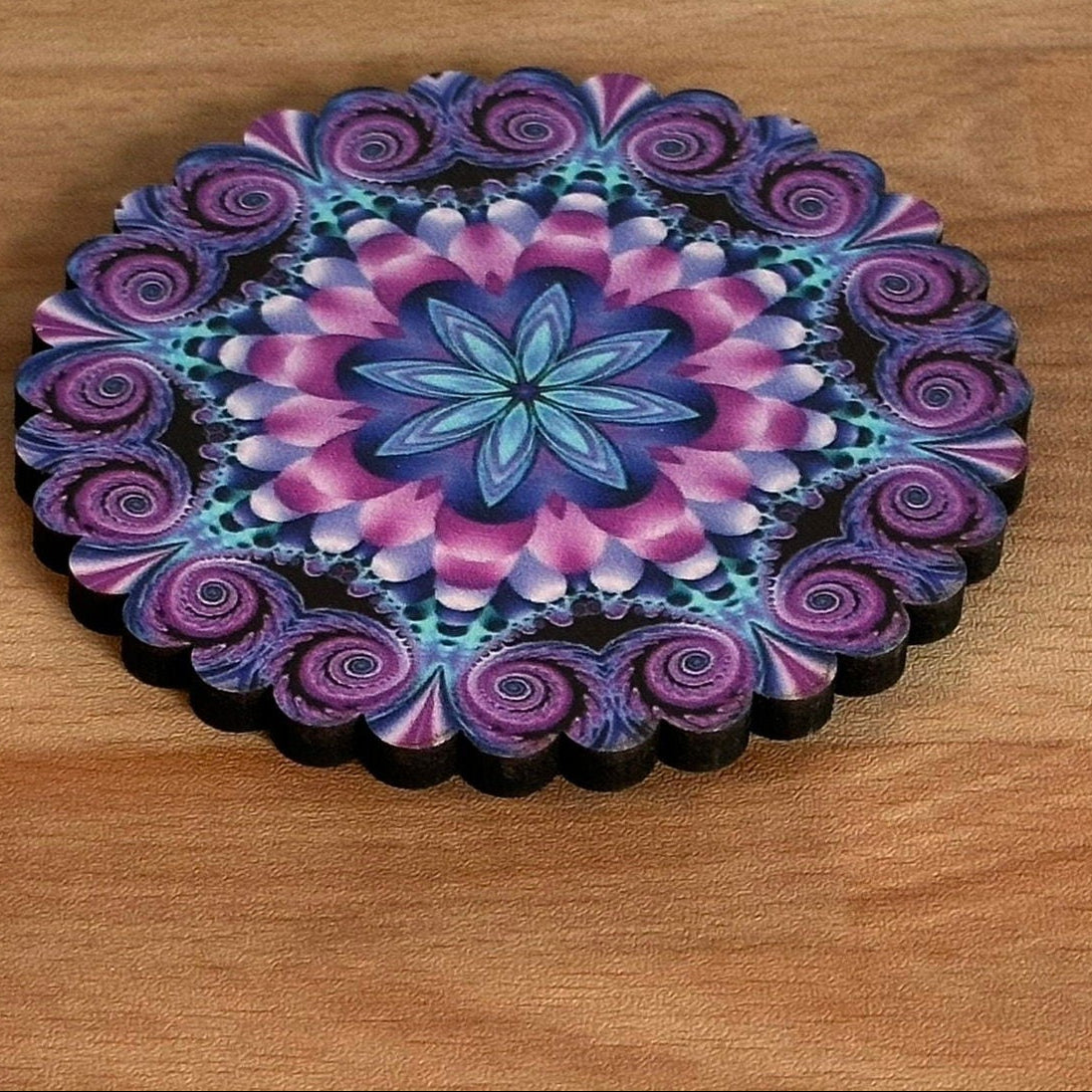 Colorful mandala coaster on a wooden surface with a geometric patterned background