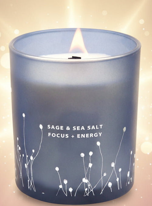 Candle in a blue container with floral designs and text 'Sage & Sea Salt Focus + Energy'.