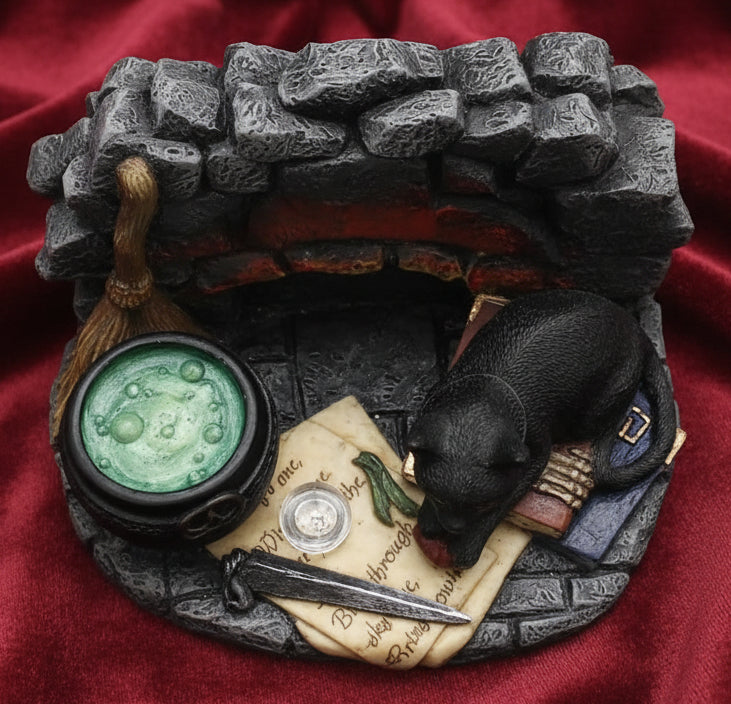 A miniature fantasy diorama or collectible miniature depicting a stone chest opening, with a black cat, parchment, inkwell, and other small details on a white background.