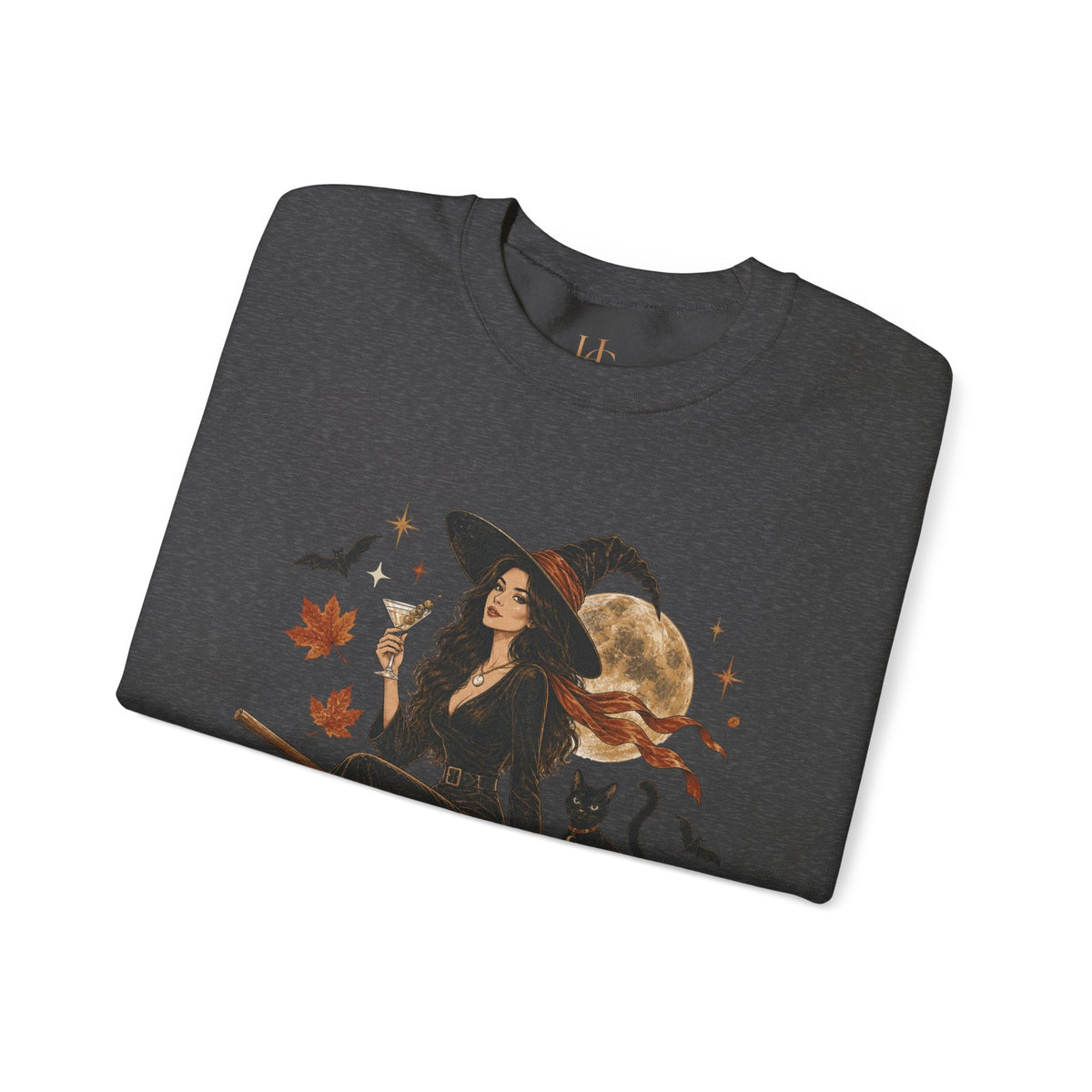 A dark heather gray folded t-shirt featuring a graphic print of a witch in a black hat and dress holding a glass, surrounded by autumn leaves, a full moon, stars, and a black cat, shown on a plain white background.