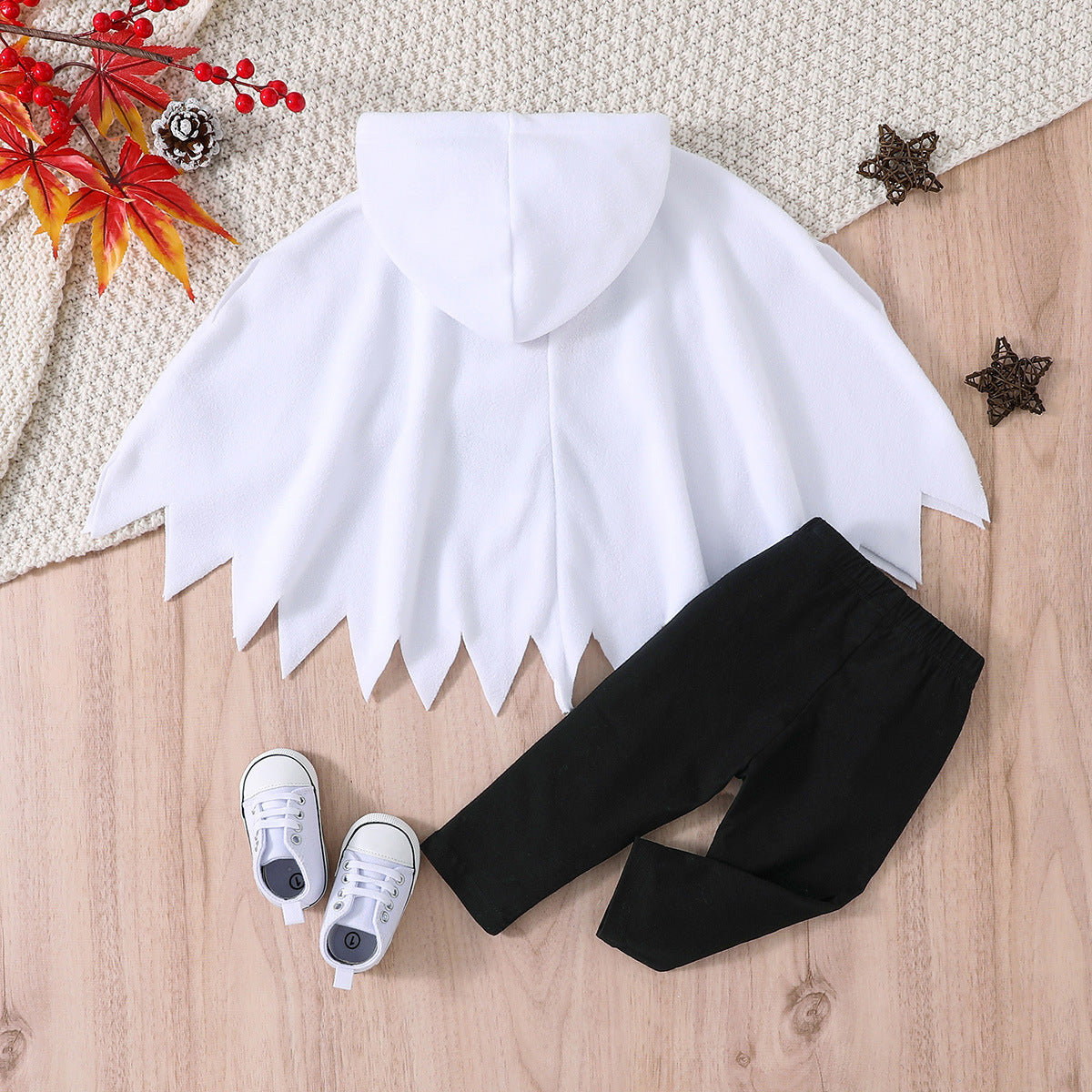 White shirt with black pants and white sneakers on a wooden surface with decorative elements.