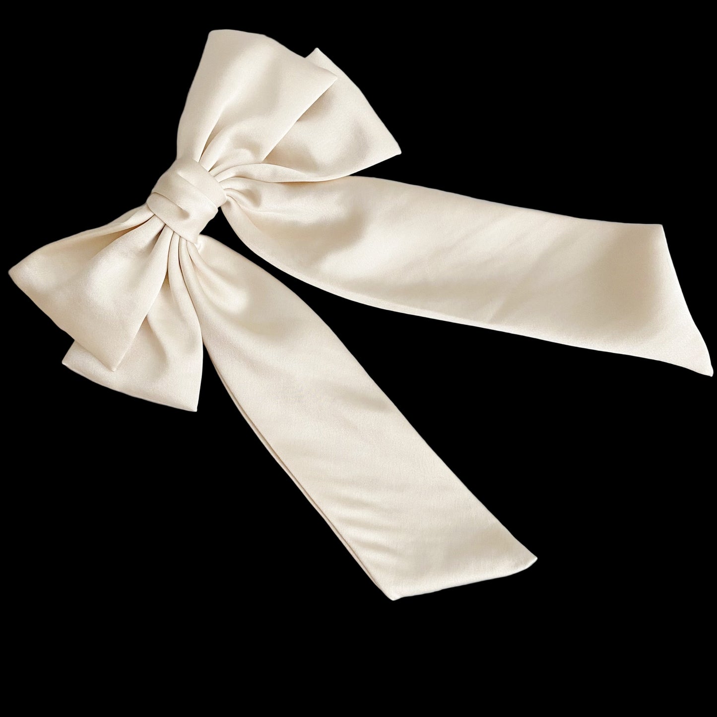Large beige satin bow on a light wooden surface