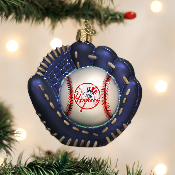 Baseball glove ornament with a baseball inside, featuring the Yankees logo, hanging on a Christmas tree.