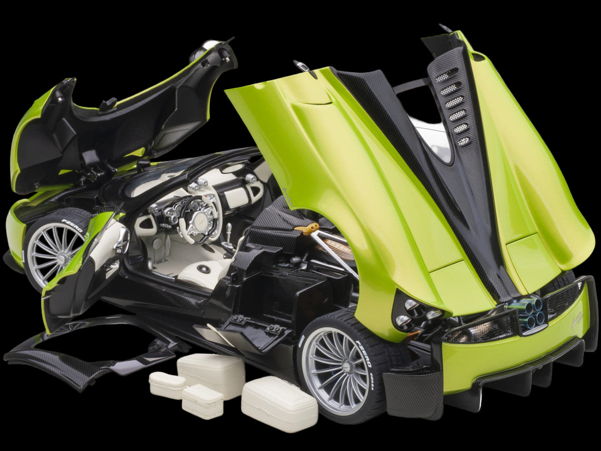 Green and black toy motorcycle model with open engine cover on a white background