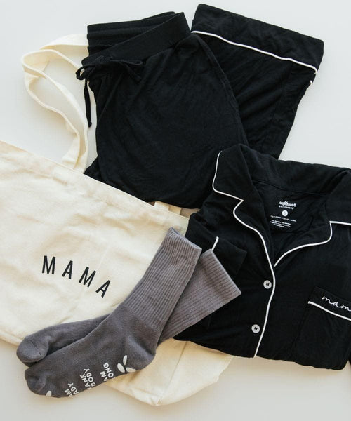 Black pajama set with white piping, gray socks, and a cream shirt with 'MAMA' text on a light background.