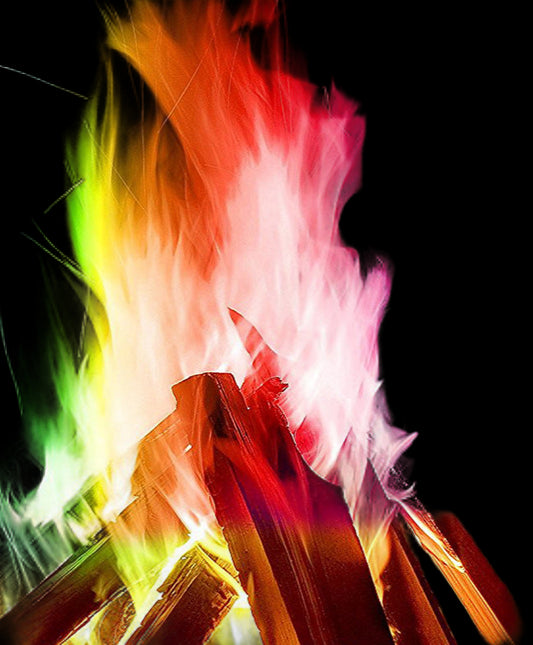 Fire with rainbow flames in a dark outdoor setting