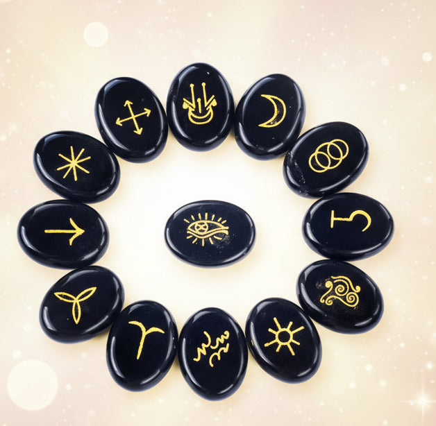 Black stones with yellow symbols arranged in a circle on a white background