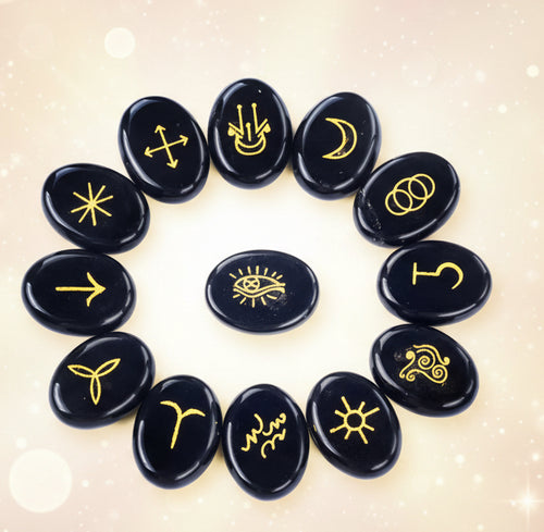 Black stones with yellow symbols arranged in a circle on a white background