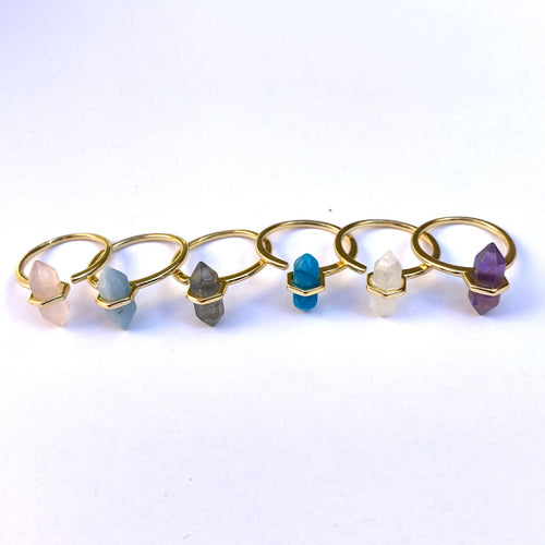 Set of gold rings with various colored gemstones on a white background