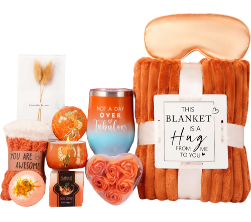 Gift set with blanket, candles, and other items in an orange box.
