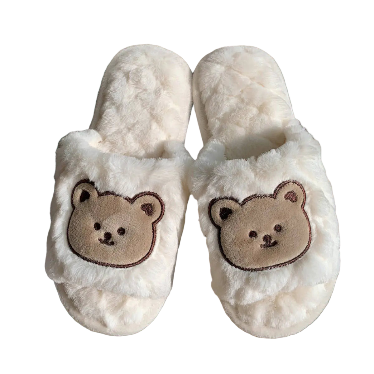 Pair of white slippers with bear face design on a wooden surface.
