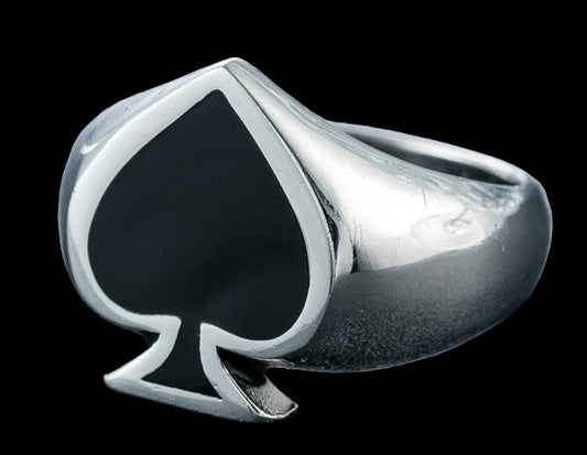 Silver ring with a black spade symbol on a gray surface