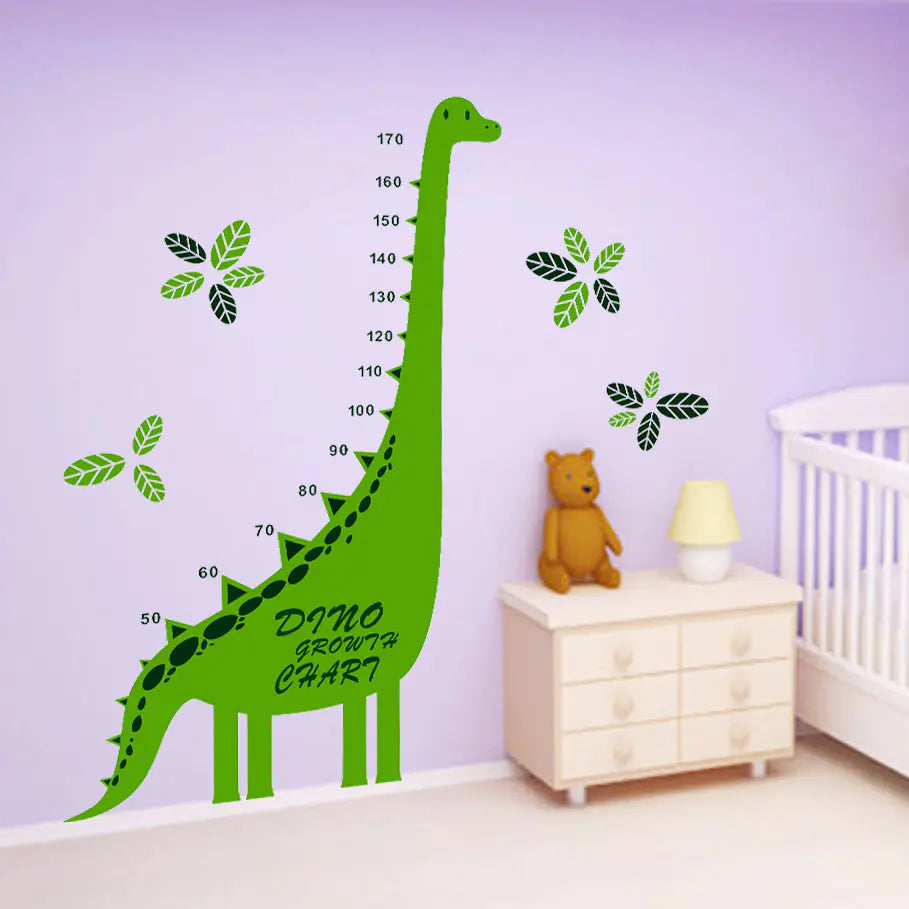 Dinosaur growth chart on a purple wall in a child's room with a teddy bear and lamp.