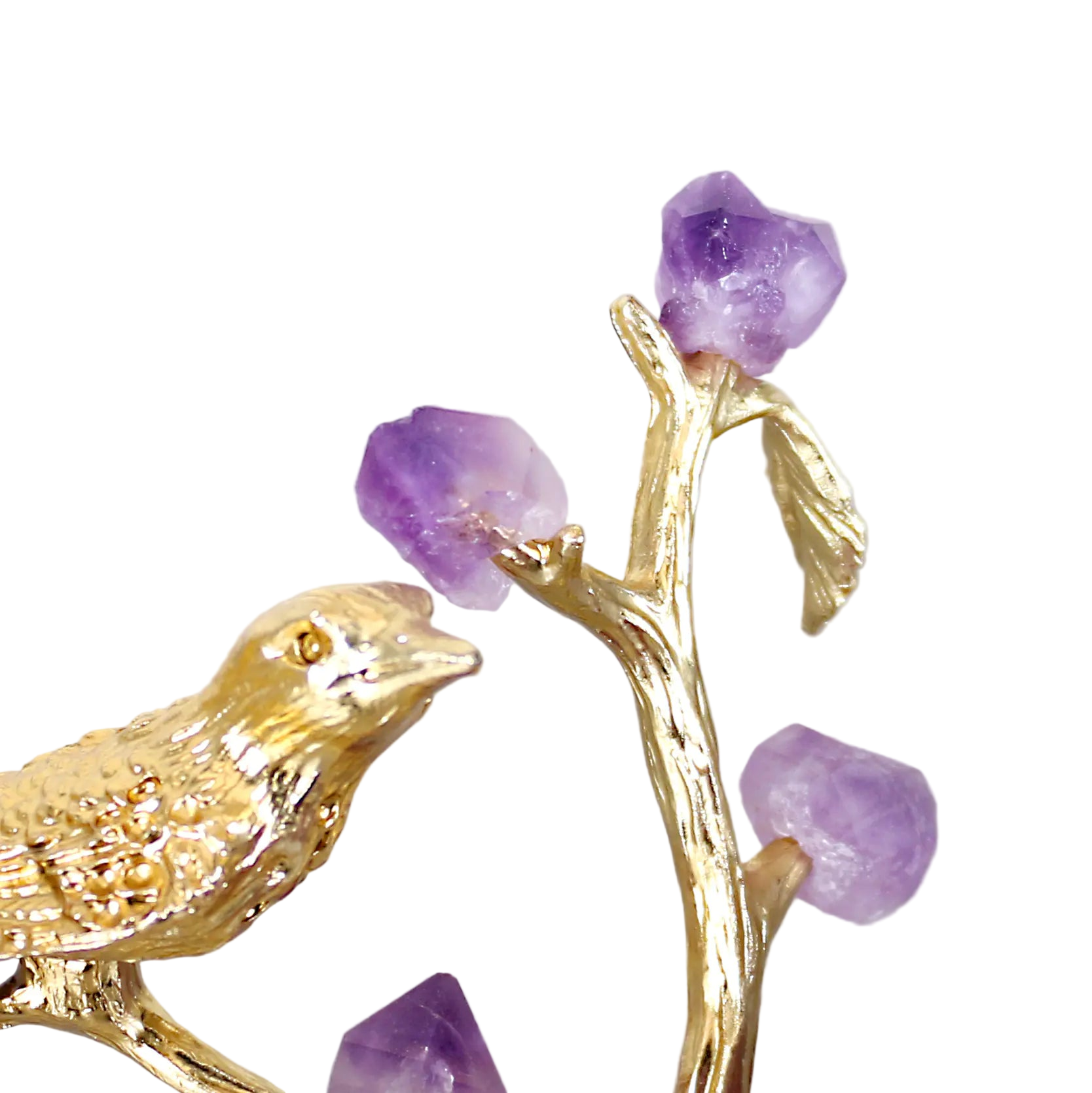 Gold bird figurine with purple amethyst crystals on a branch against a light gray background