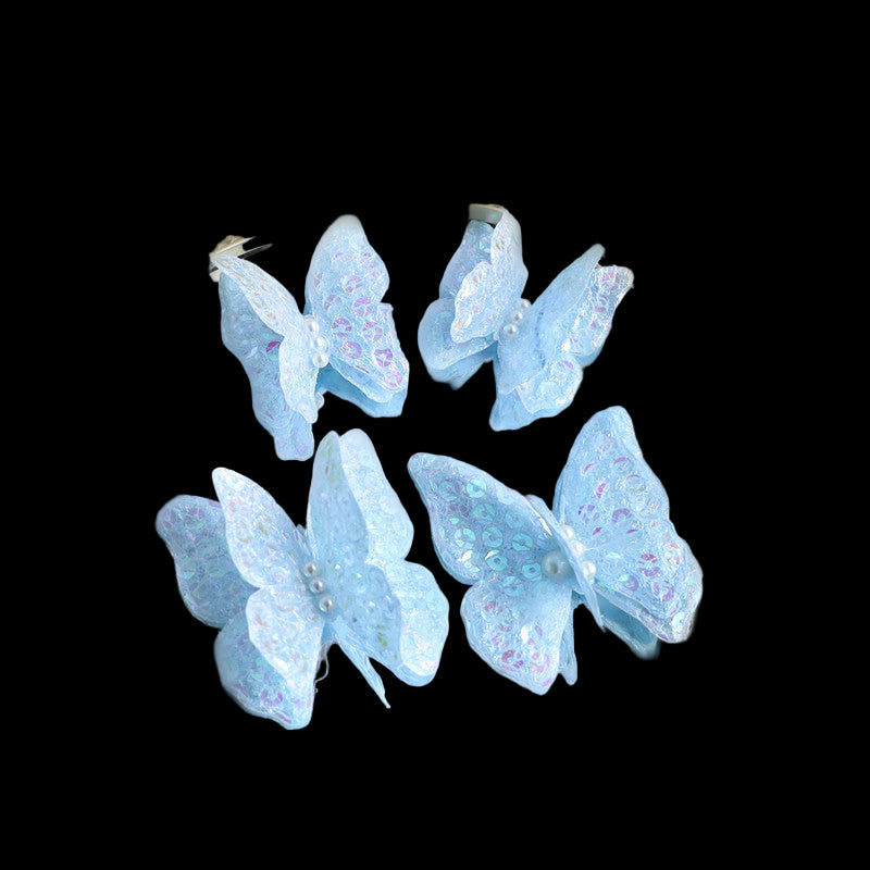 Blue butterfly earrings with glitter on a neutral background