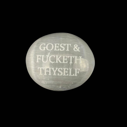Round stone with engraved text on a black background