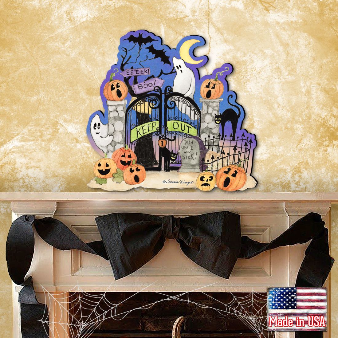 Halloween-themed decorative sign with pumpkins, ghosts, and a gate on a mantel.