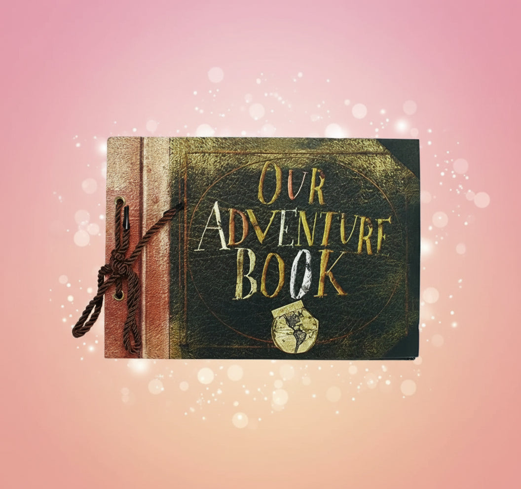 Book titled 'Our Adventure Book' with decorative elements on a wooden surface.