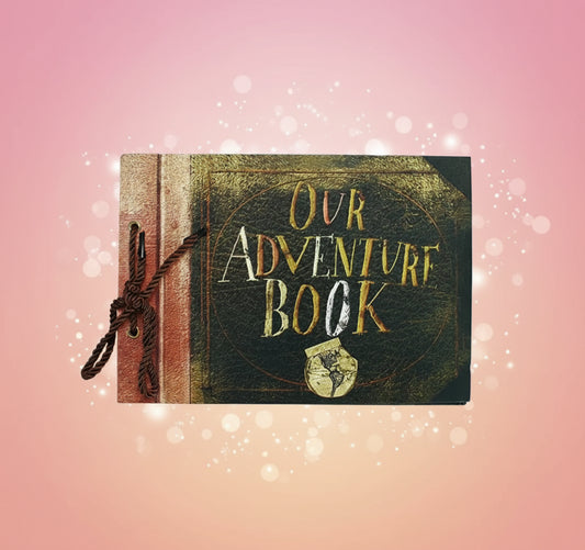 Book titled 'Our Adventure Book' with decorative elements on a wooden surface.