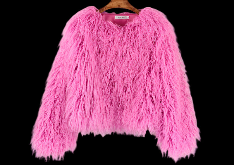 Pink fluffy sweater on a hanger against a wooden panel background