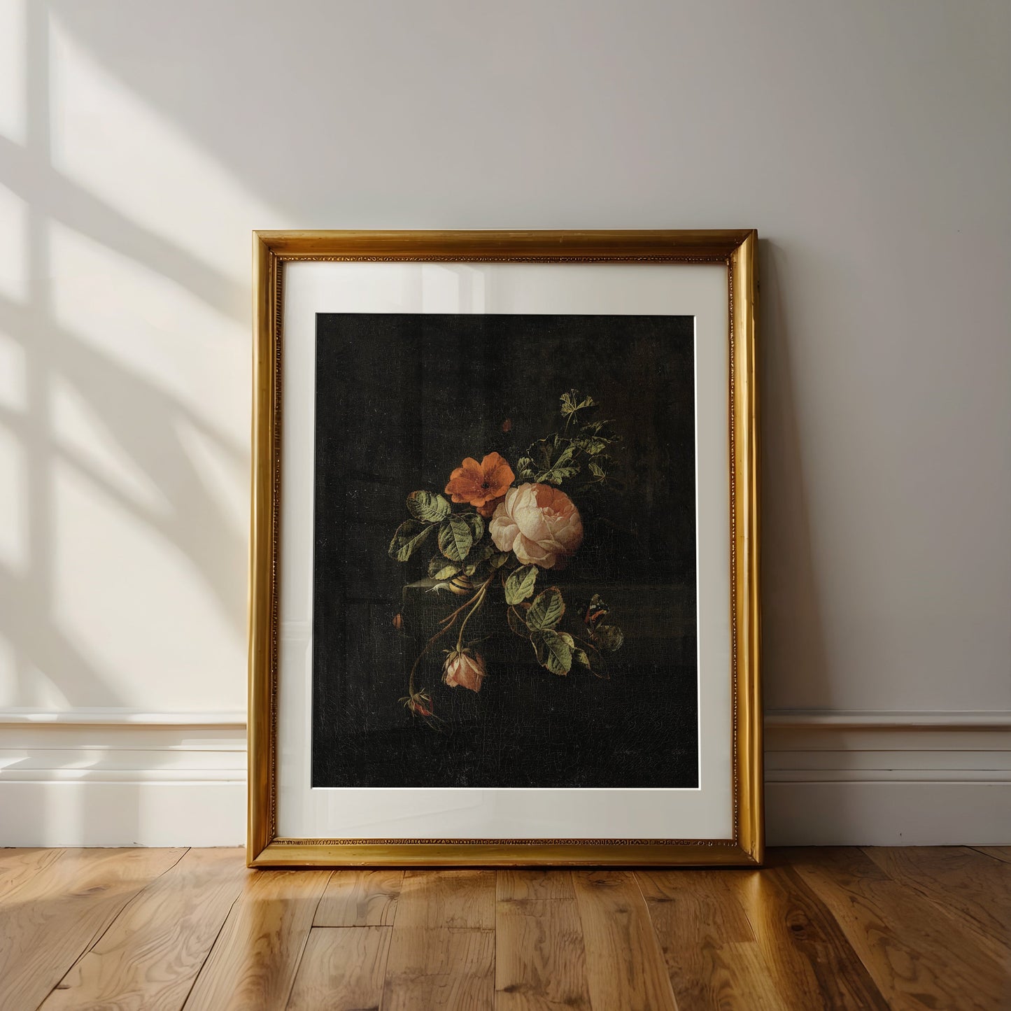 Framed floral artwork on a wall with sunlight casting shadows.