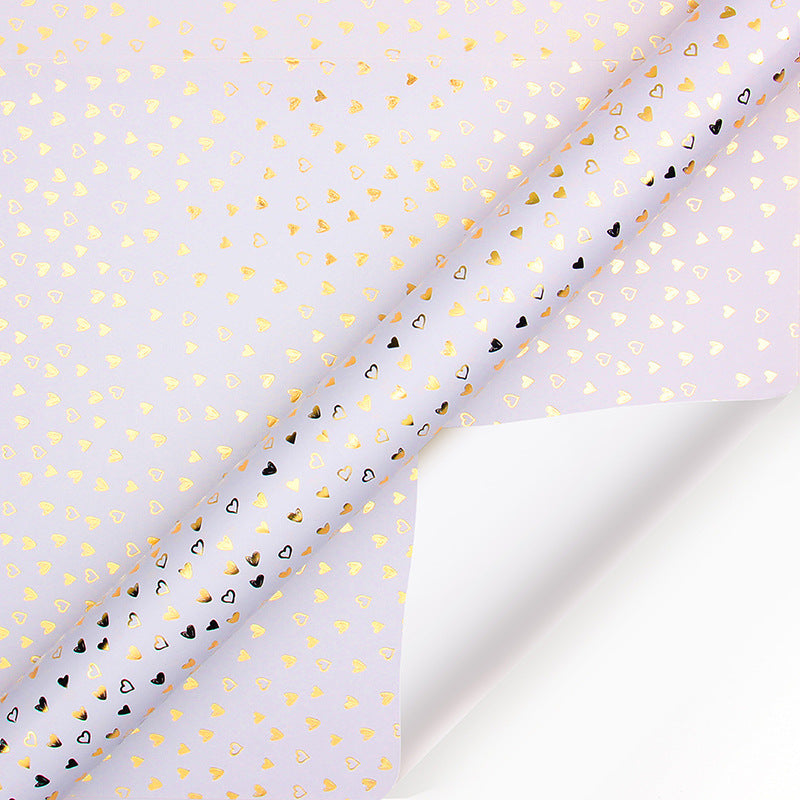Translucent paper with gold and black heart patterns on a white background
