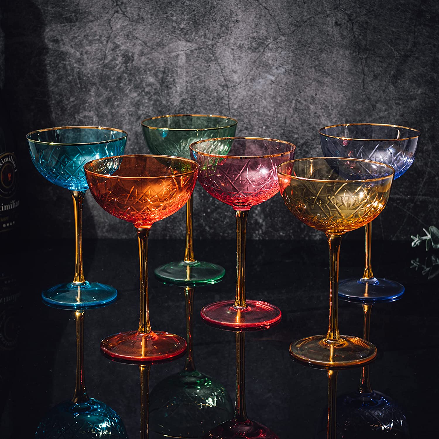 Set of colorful cocktail glasses on a dark surface with a dark background