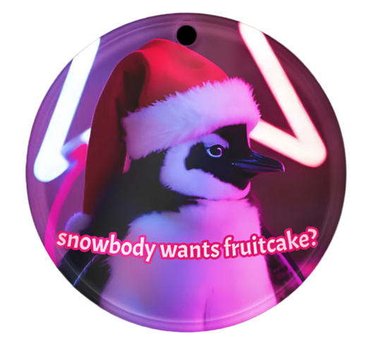 Circular ornament with a penguin wearing a Santa hat and text 'snowbody wants fruitcake?' on a white background.