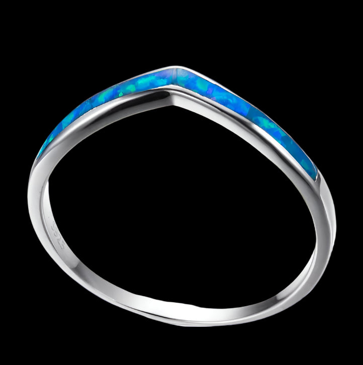 Silver ring with blue opal inlay on a white background