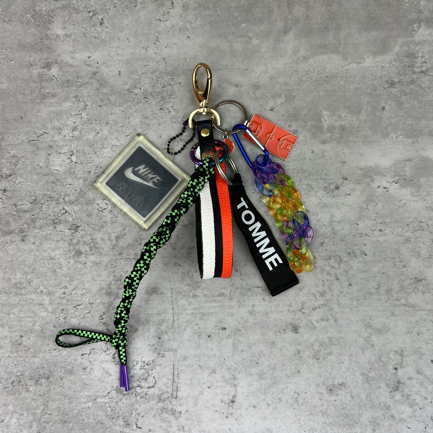 Keychain with various tags and a lanyard on a concrete surface