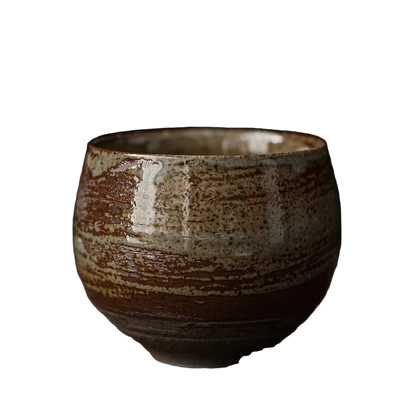 Ceramic cup with brown and beige glaze on a dark background