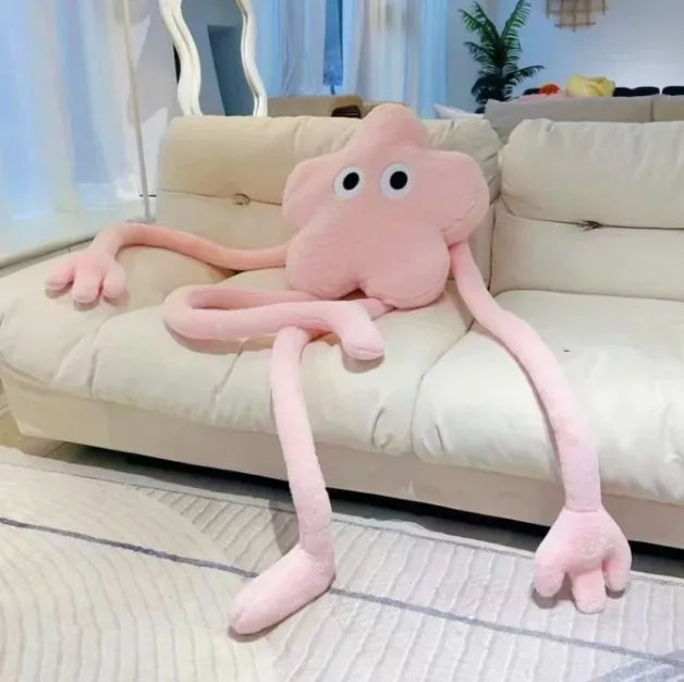 Pink octopus plush toy on a beige couch in a living room setting